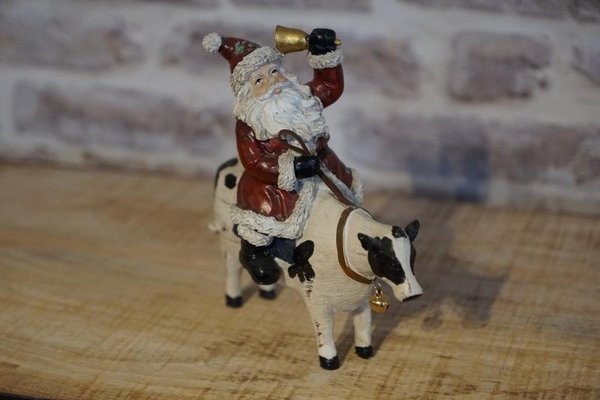 Dekorativer Weihnachtsmann auf einer Kuh